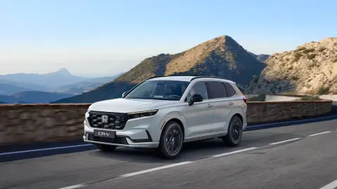 CR-V Plug-in Hybrid SUV, der kører på vejen i et bjergområde, set forfra.