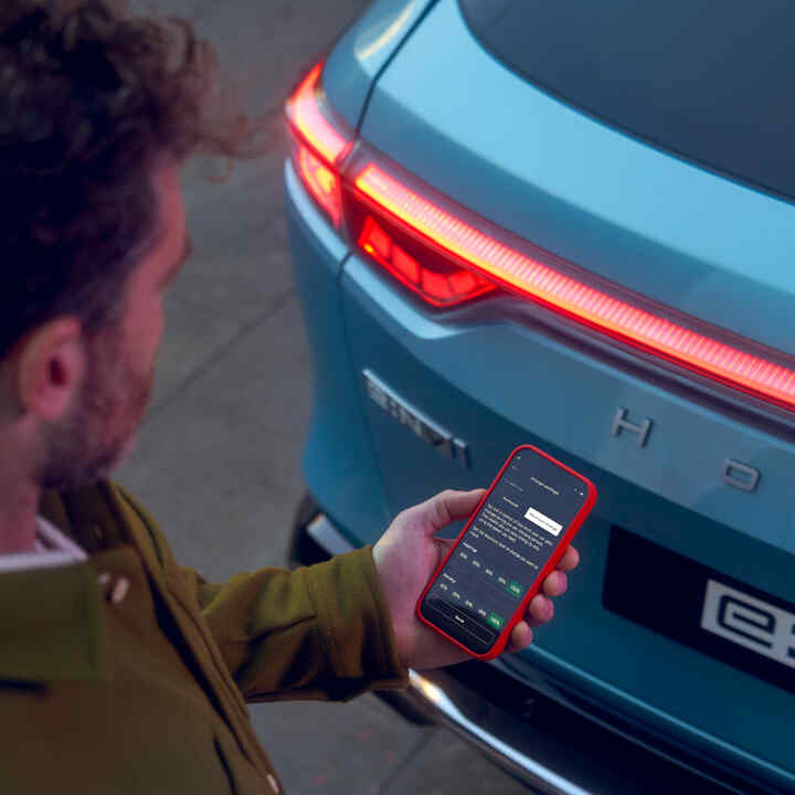 My Honda+ app nærbillede af en person, der bruger sin telefon uden for bilen