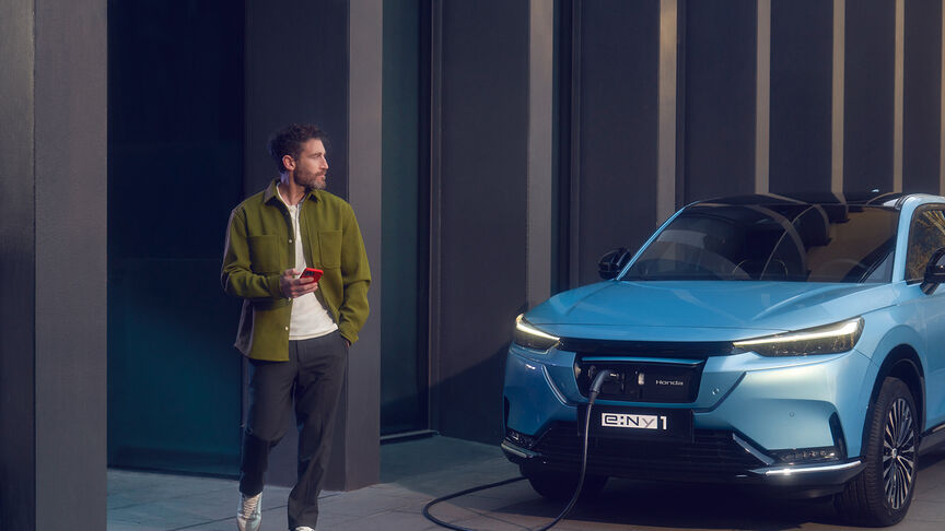 Honda e:Ny1, som kører igennem byen, set skråt forfra.
